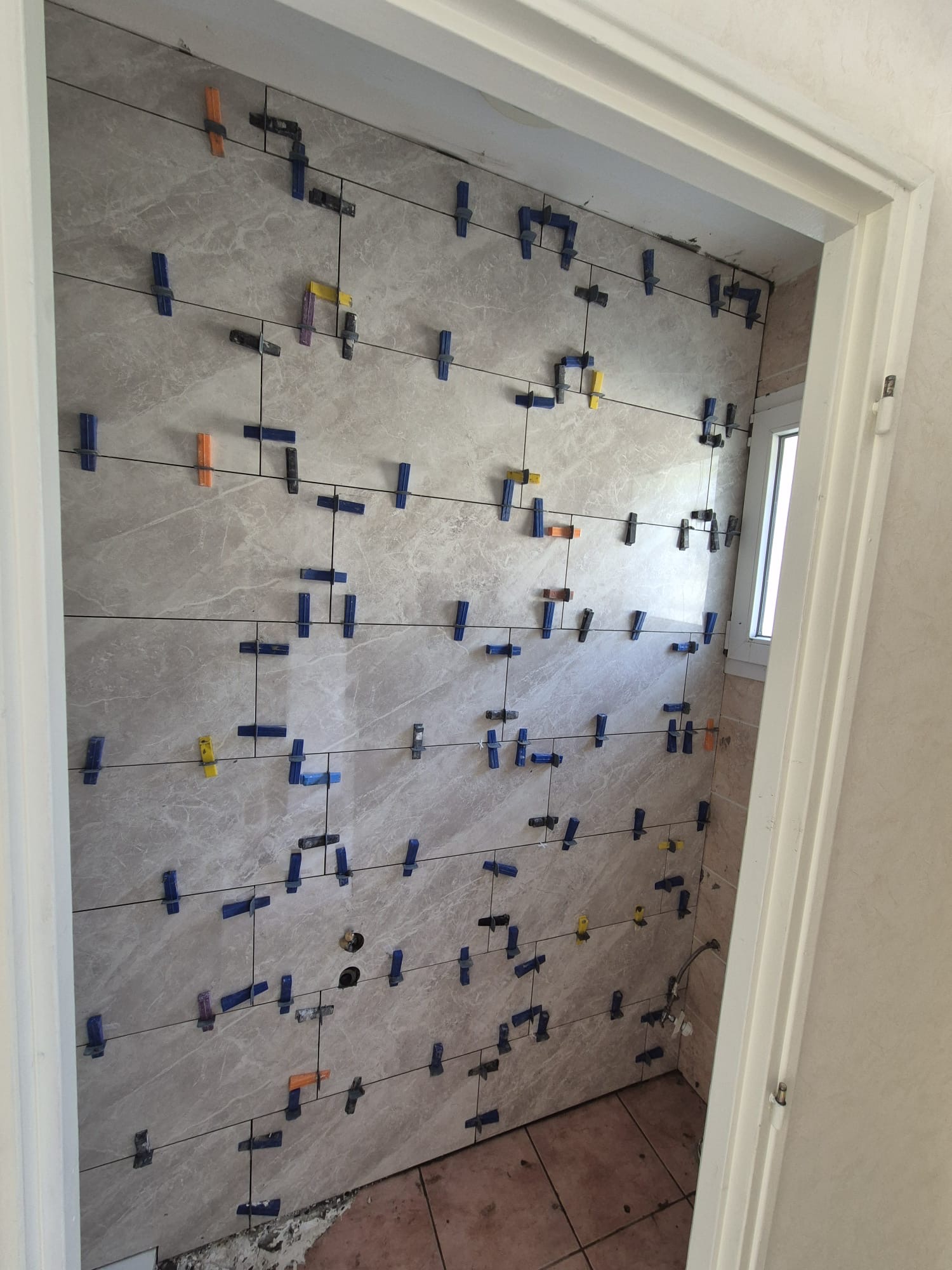 Pose de carrelage mural effet marbre avec croisillons autonivelants