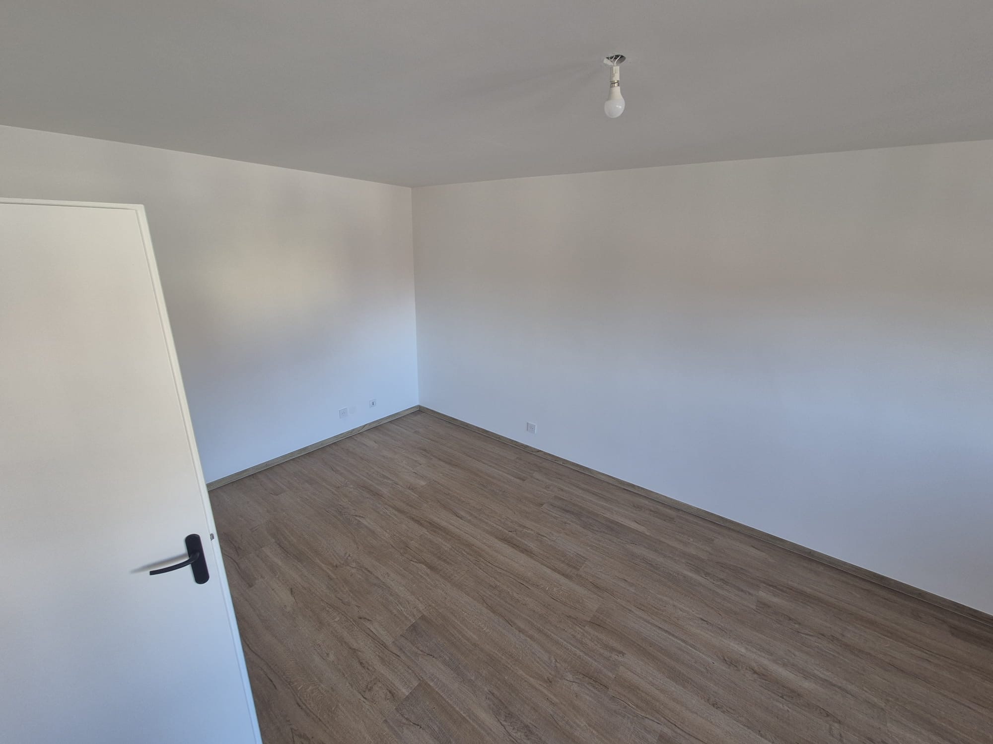 Chambre rénovée avec parquet stratifié et murs peints